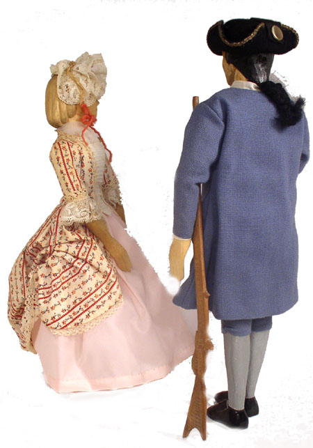 Back view of husband and wife wooden dolls dressed in period costumes of America in 1775
