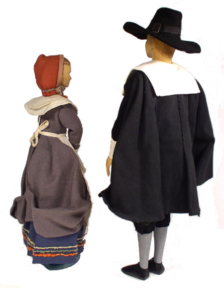 Back view of husband and wife wooden dolls dressed in period costumes of America in 1630