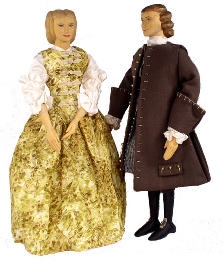 Front view of husband and wife wooden dolls dressed in period costumes of America in 1677