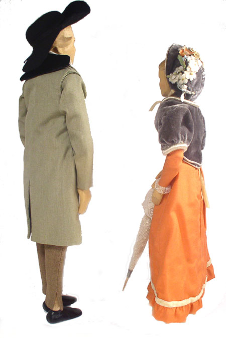 Back view of husband and wife wooden dolls dressed in period costumes of America in 1811