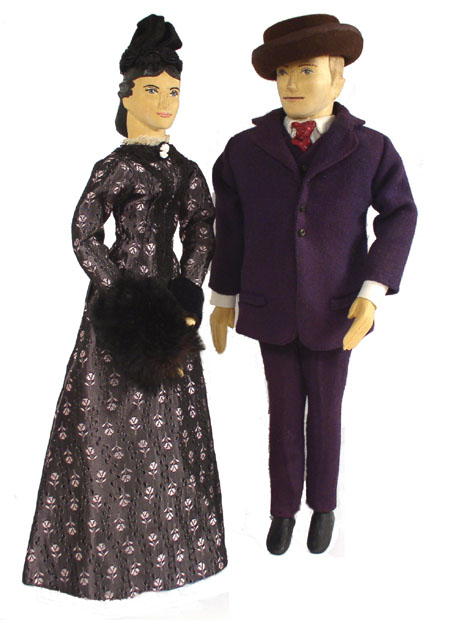Front view of husband and wife wooden dolls dressed in period costumes of America in 1875