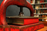 Repaired book laying on its side, on a book press.