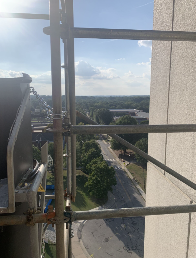 View of UNCG's campus facing Walker Avenue. Rails in the foreground.