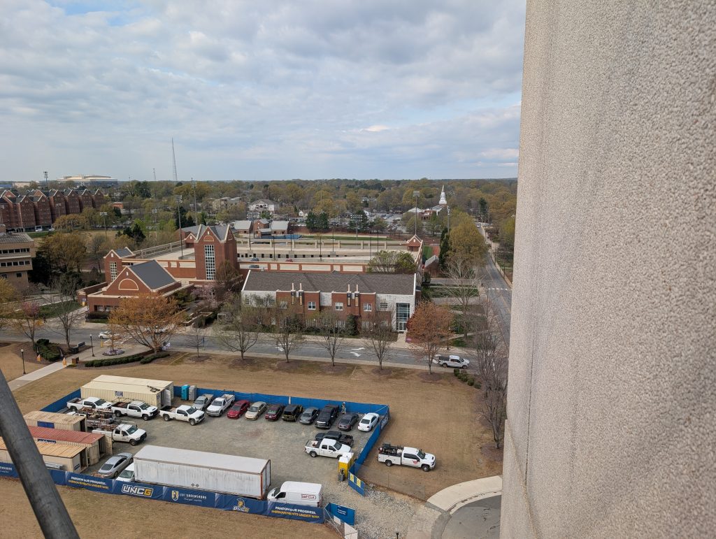 Overlook of campus with streets and parked cars visible.