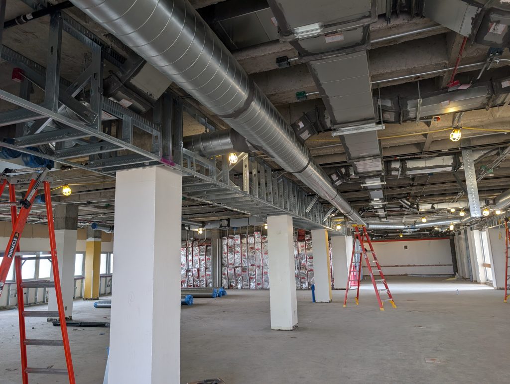 A construction site with duct work and columns.
