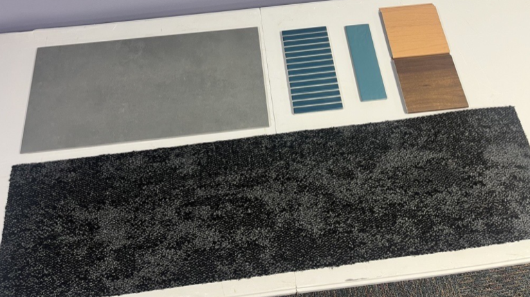 Carpet swatch and various floor samples on a table.